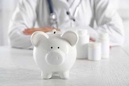 Foto: Arzt sitz hinter Sparschwein