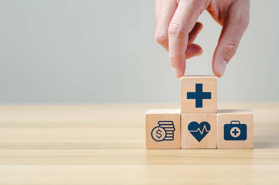 Foto: Hand legt einen Holzblock auf andere Blöcke